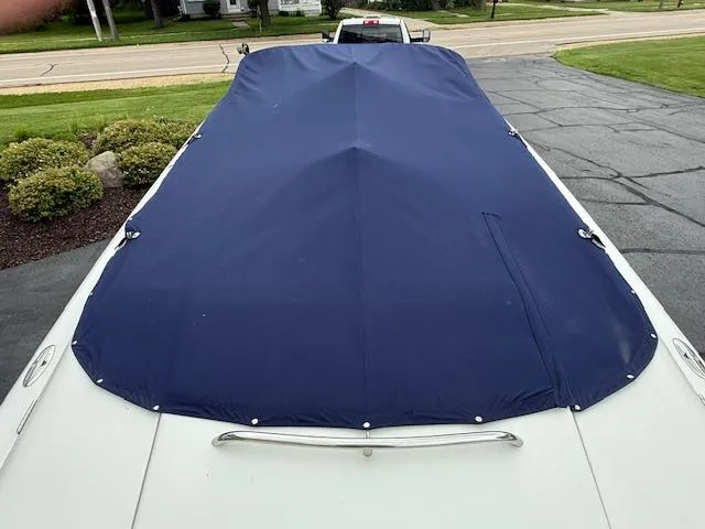 Slide: The Image of 2001 Chris-Craft Launch 25 boat with blue cover, parked on driveway. - 34