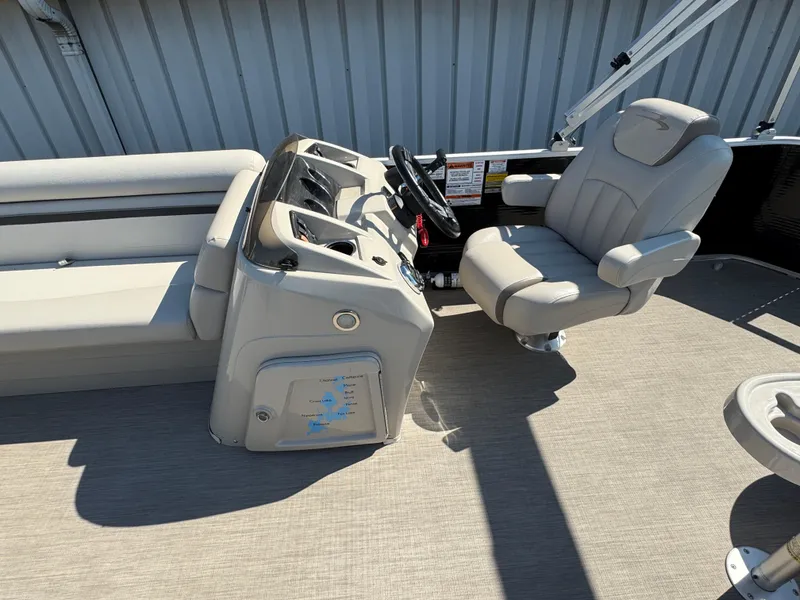 Slide: The Image of 2017 Bennington 21 SLX boat interior with helm and seating, featuring beige upholstery. - 9