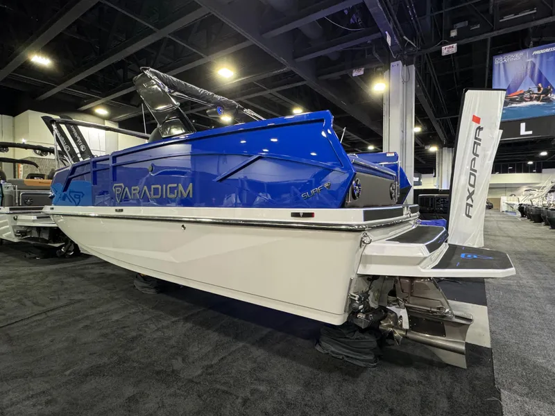 Slide: The Image of 2025 Paradigm 236 boat displayed indoors, featuring sleek blue and white design. - 2
