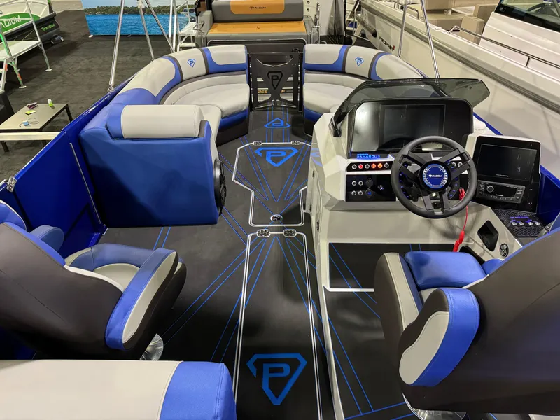 Slide: The Image of 2025 Paradigm 236 boat interior with blue and gray seating, modern dashboard, and steering wheel. - 4