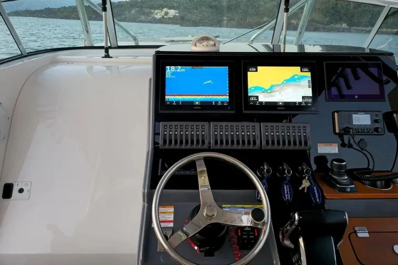 Slide: The Image of 2024 Victory V400 Open Sea boat dashboard with navigation screens and steering wheel. - 4