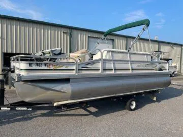 Slide: The Image of 1999 Princecraft Sportfisher 20 pontoon boat on trailer, parked near storage facility. - 9