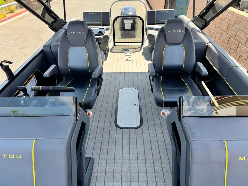 Slide: The Image of 2024 Manitou Explore 24 Navigator boat interior with sleek seating and modern design. - 12