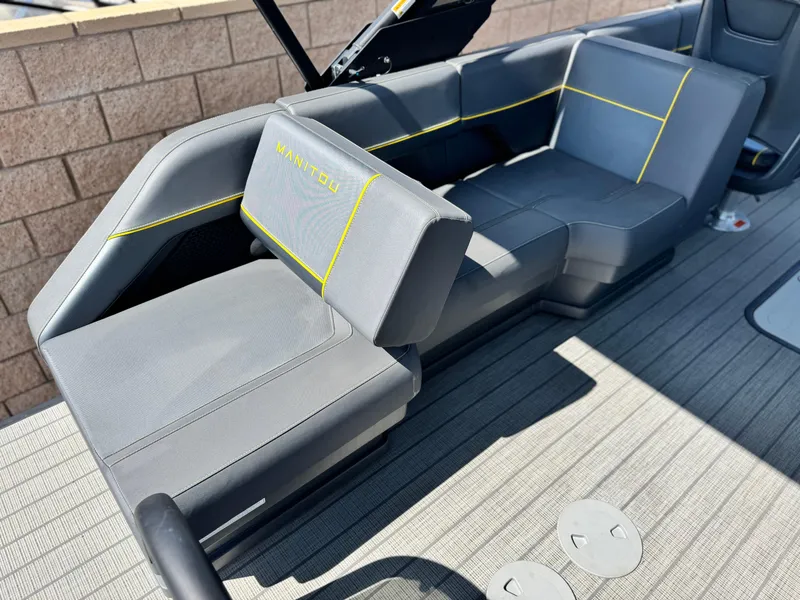 Slide: The Image of 2024 Manitou Explore 24 Navigator boat interior with gray seating and yellow accents. - 18