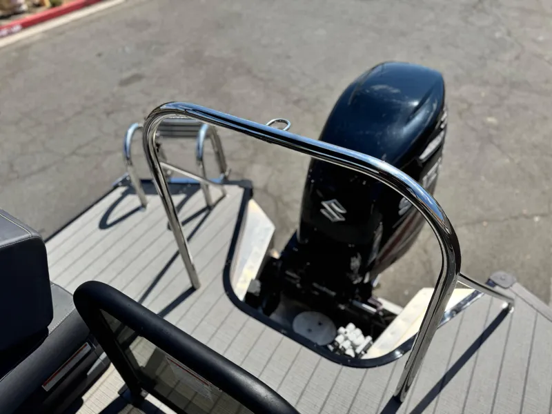 Slide: The Image of 2024 Manitou Explore 24 Navigator boat with Suzuki outboard motor and stainless steel railing. - 19