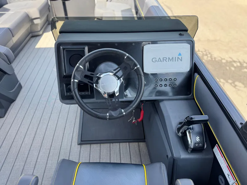 Slide: The Image of 2024 Manitou Explore 24 Navigator dashboard with Garmin system and steering wheel. - 25