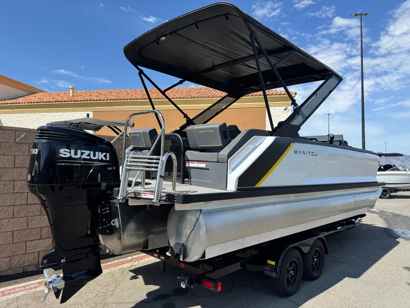 Slide: The Image of 2024 Manitou Explore 24 Navigator pontoon boat with Suzuki engine, parked outdoors. - 6