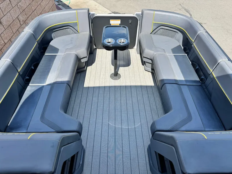 Slide: The Image of 2024 Manitou Explore 24 Navigator boat interior with sleek seating and central table. - 9