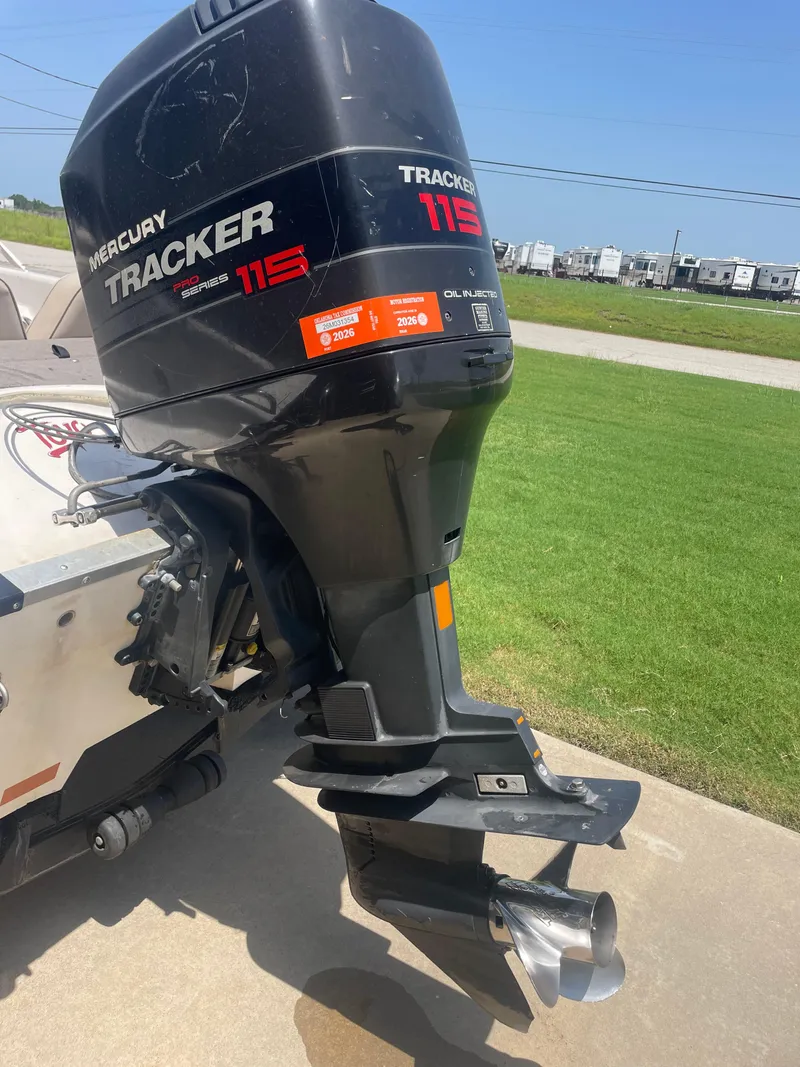 Slide: The Image of Mercury Tracker 115 outboard motor on a 1995 Nitro 185SF boat, parked on concrete. - 7