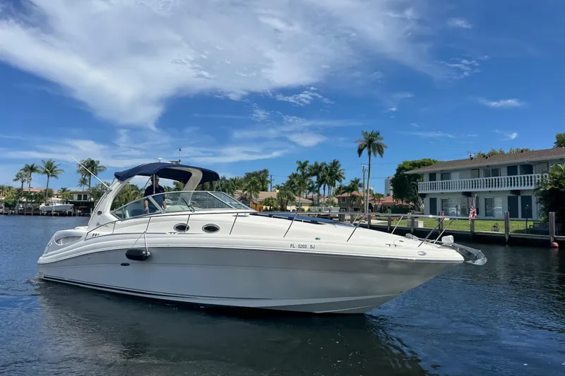 The Image of 2004 Sea Ray 340 Sundancer boat on a sunny day, docked near palm trees. - 0