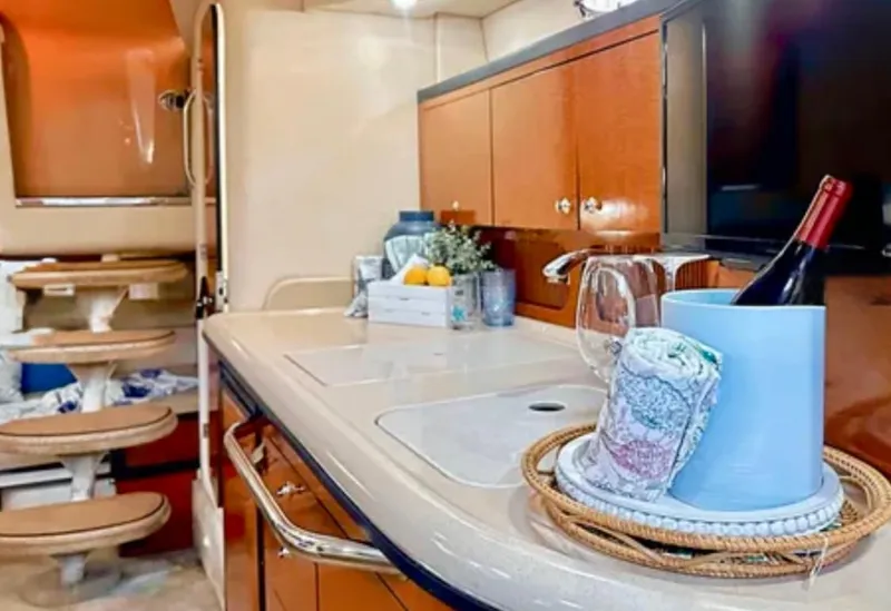 Slide: The Image of 2004 Sea Ray 340 Sundancer cockpit with white leather seats and wooden flooring. - 11