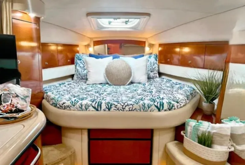 Slide: The Image of 2004 Sea Ray 340 Sundancer helm with steering wheel and control panel, surrounded by lush greenery. - 13