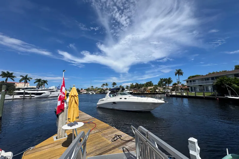 Slide: The Image of 2004 Sea Ray 340 Sundancer interior kitchen with sink, microwave, and wooden cabinetry. - 23