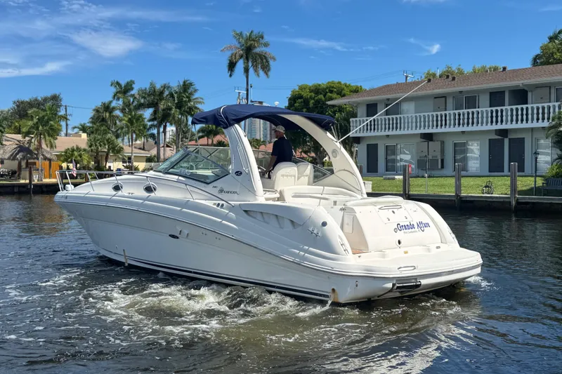 Slide: The Image of 2004 Sea Ray 340 Sundancer yacht on calm water, with a clear blue sky backdrop. - 38