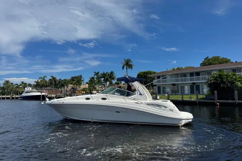 Slide: The Image of 2004 Sea Ray 340 Sundancer yacht cruising on a sunny day with palm trees in the background. - 40