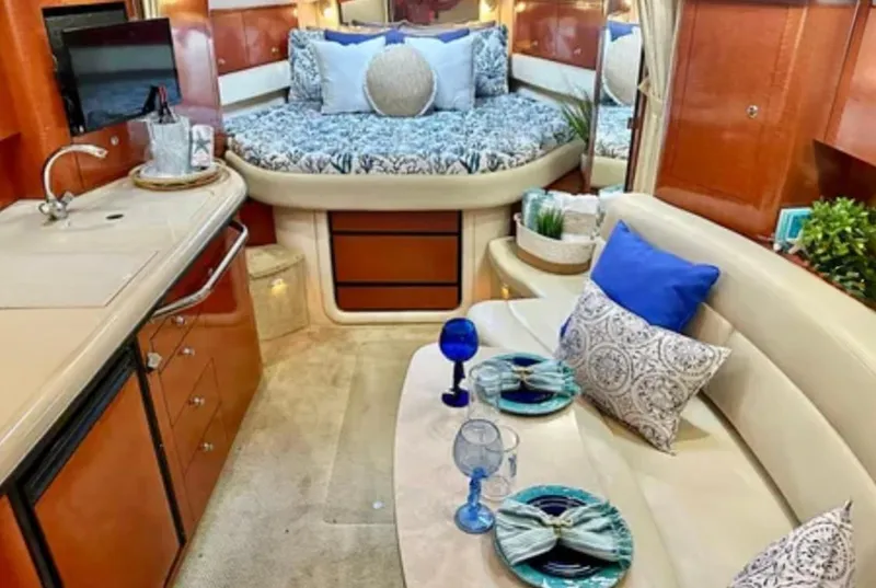 Slide: The Image of 2004 Sea Ray 340 Sundancer interior with white seating and wooden flooring. - 6