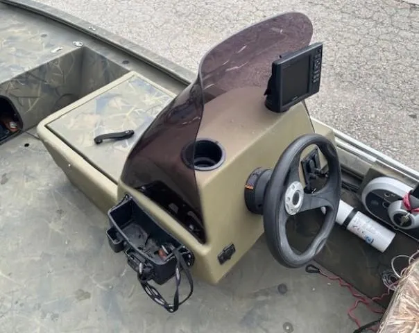 Slide: The Image of 2018 Tracker Grizzly 1648 SC boat console with steering wheel and electronic display. - 12