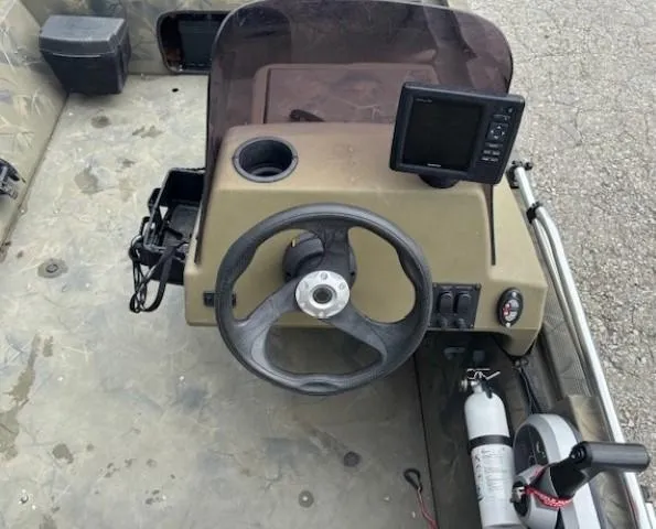 Slide: The Image of 2018 Tracker Grizzly 1648 SC boat console with steering wheel and navigation display. - 13