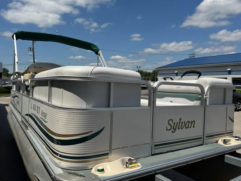 Slide: The Image of 2003 Sylvan 820 Mirage Cruise pontoon boat with canopy, parked outdoors under a blue sky. - 4