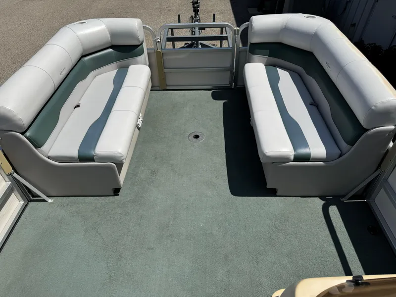Slide: The Image of 2003 Sylvan 820 Mirage Cruise interior with cushioned seating and green carpet. - 5