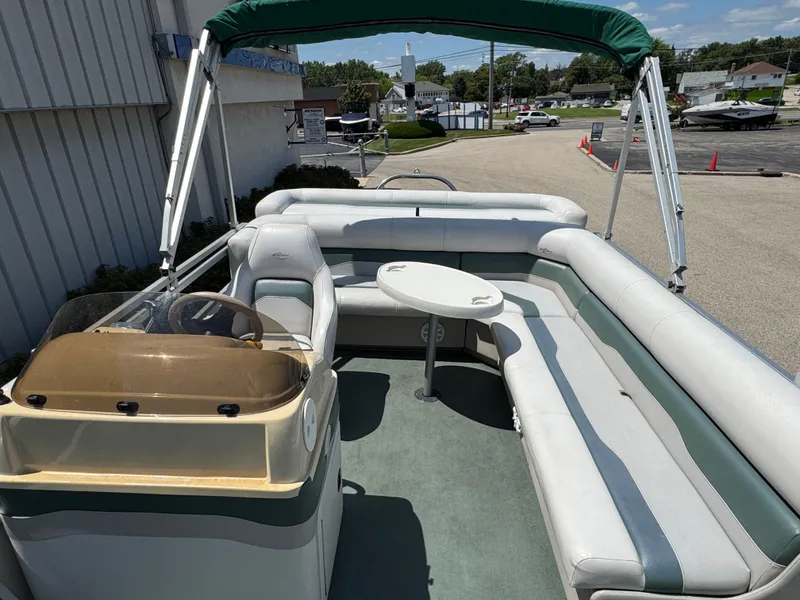 Slide: The Image of 2003 Sylvan 820 Mirage Cruise pontoon boat with seating and canopy, parked outdoors. - 7