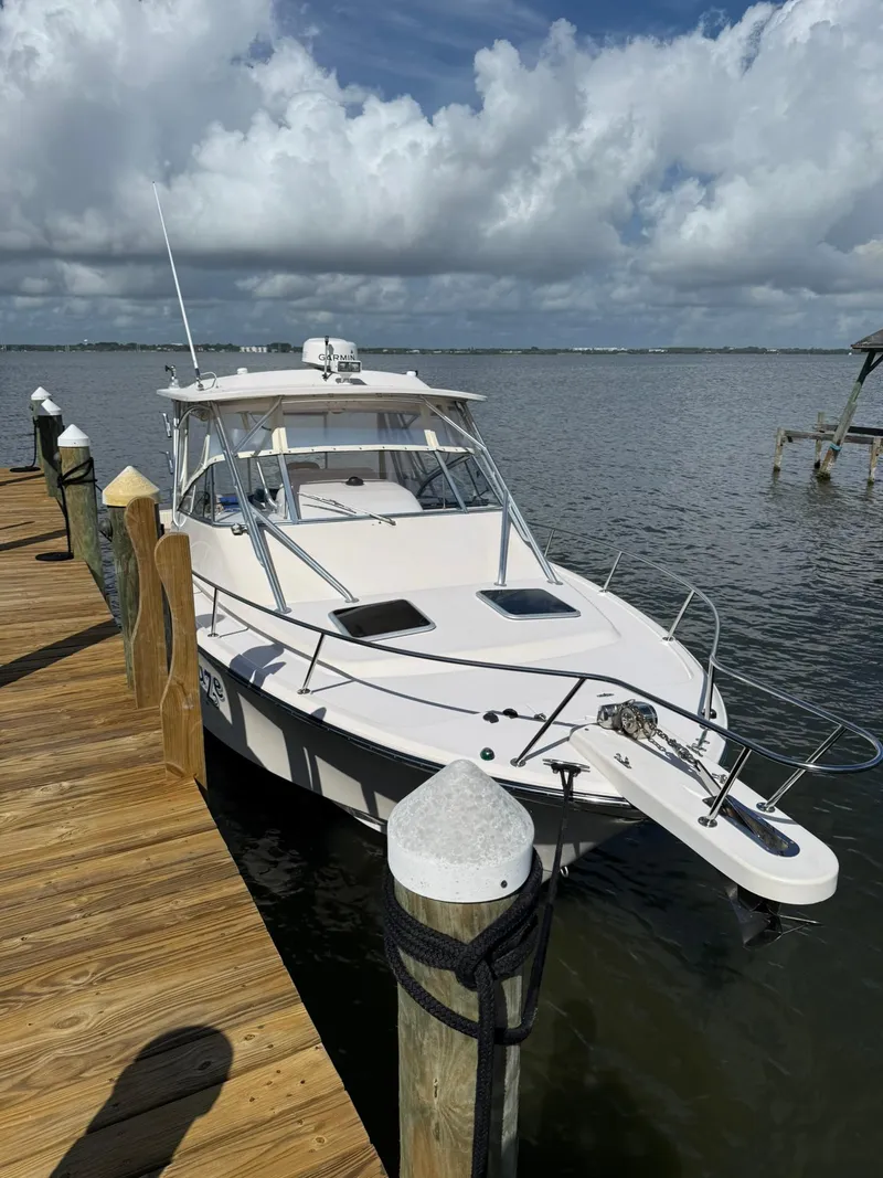 Slide: The Image of 2007 Grady-White Express 330 boat docked by wooden pier under cloudy sky. - 13