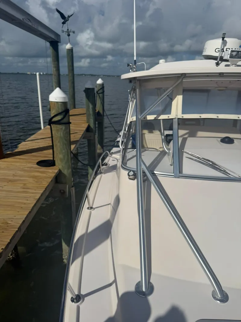 Slide: The Image of 2007 Grady-White Express 330 boat docked by wooden pier under cloudy sky. - 19