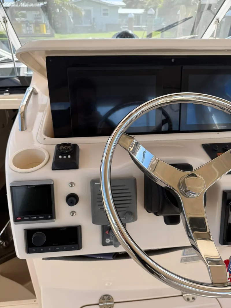 Slide: The Image of 2007 Grady-White Express 330 helm with steering wheel and navigation controls. - 42