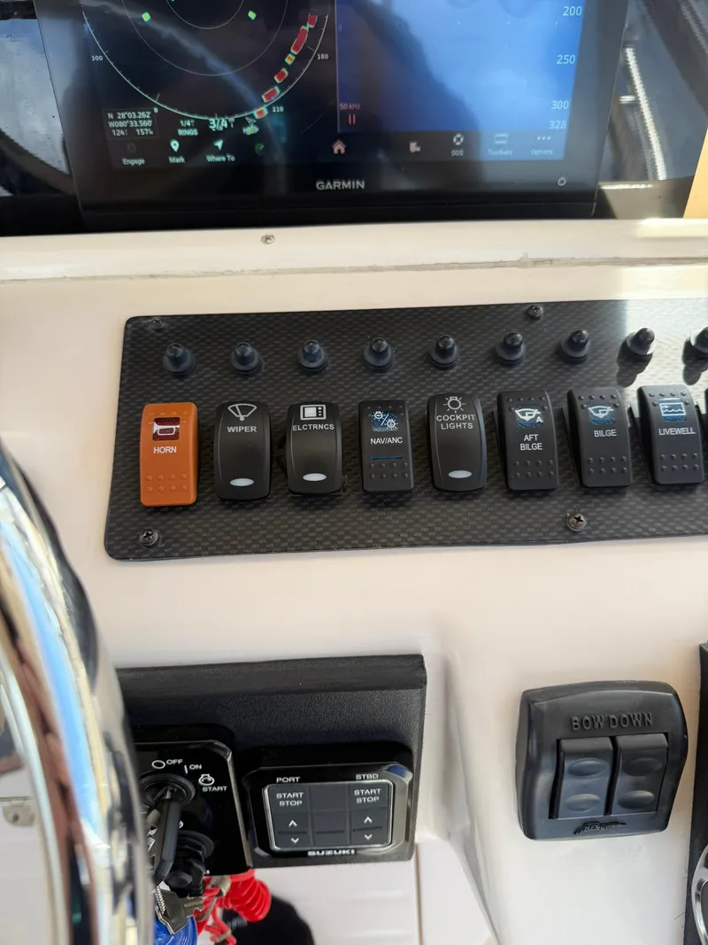 Slide: The Image of Control panel of a 2007 Grady-White Express 330 boat with various switches and a Garmin display. - 47
