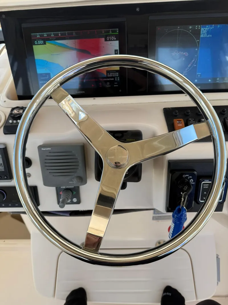 Slide: The Image of Steering wheel and controls of a 2007 Grady-White Express 330 boat. - 49