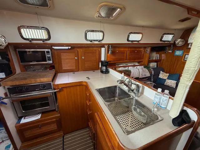 Slide: The Image of 2003 Caliber 40 LRC SE yacht interior with kitchen, sink, and wooden cabinetry. - 23