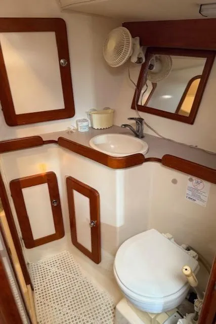 Slide: The Image of 2003 Caliber 40 LRC SE yacht bathroom with sink, toilet, mirror, and storage cabinets. - 38