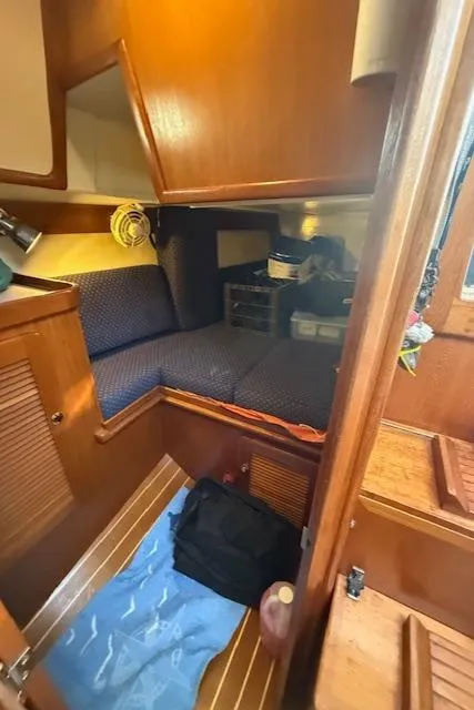Slide: The Image of Cozy cabin interior of 2003 Caliber 40 LRC SE sailboat with wooden finish and blue cushions. - 39