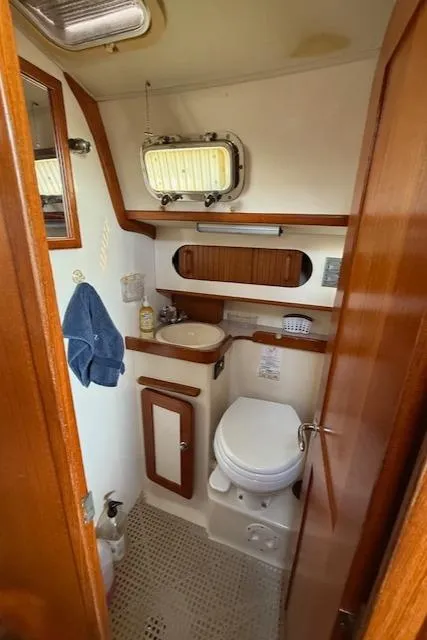 Slide: The Image of Compact bathroom in 2003 Caliber 40 LRC SE yacht with wooden accents and porthole. - 40