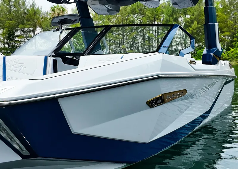 Slide: The Image of 2025 Nautique G23 Paragon boat on water, sleek design, blue and white color scheme. - 18