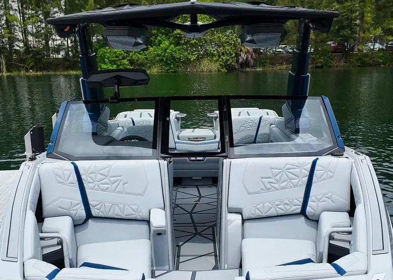 Slide: The Image of 2025 Nautique G23 Paragon boat interior with luxurious seating and modern design on a serene lake. - 25