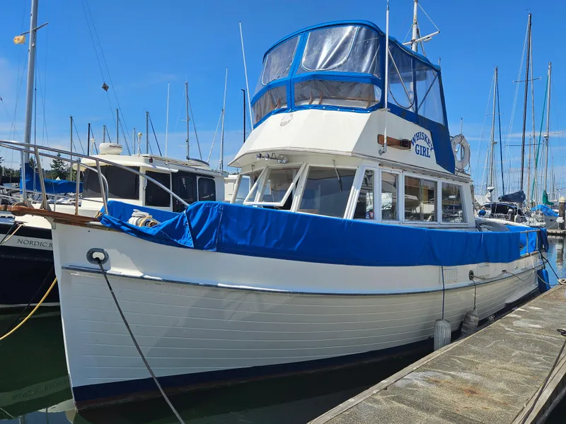 The Image of 1973 Grand Banks 36 Classic boat docked, featuring blue covers and a white hull. - 0