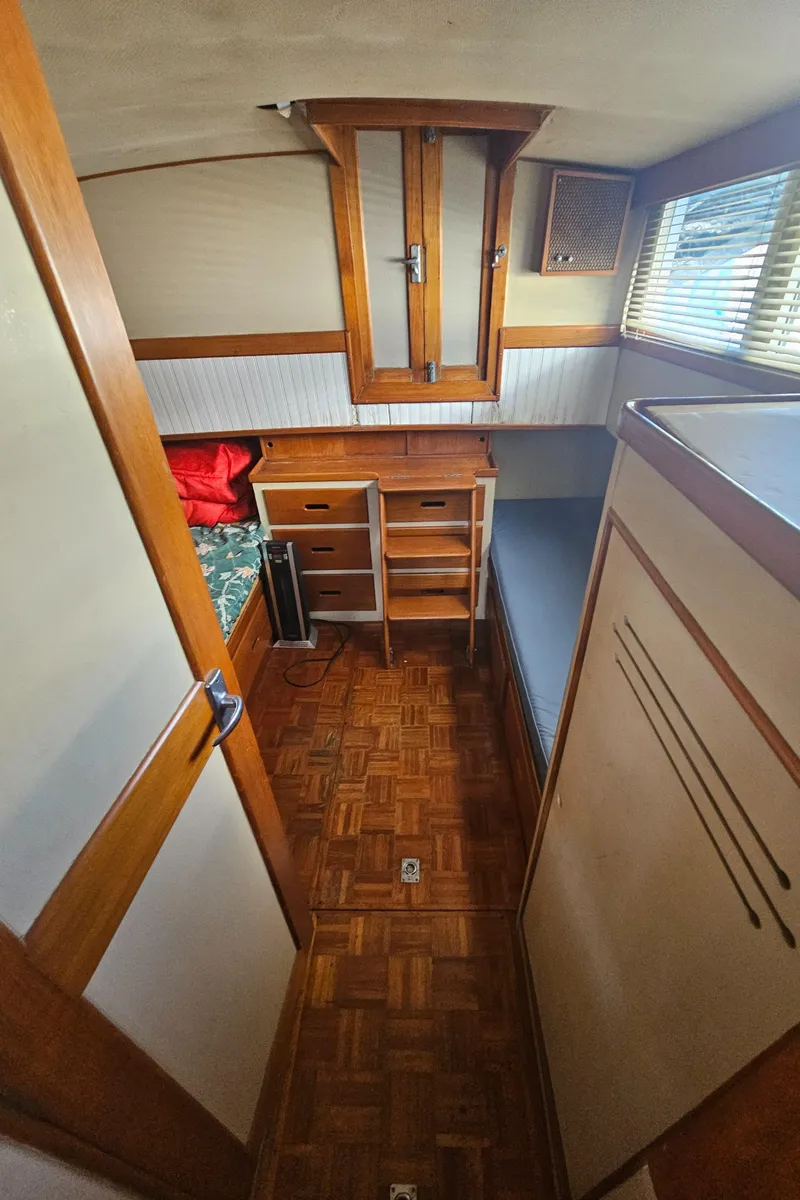 Slide: The Image of 1973 Grand Banks 36 Classic cabin interior with wood furnishings and cozy sleeping area. - 10