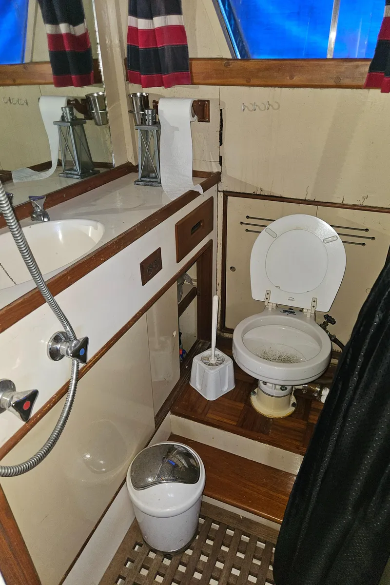 Slide: The Image of 1973 Grand Banks 36 Classic boat bathroom with sink, toilet, and nautical decor. - 11
