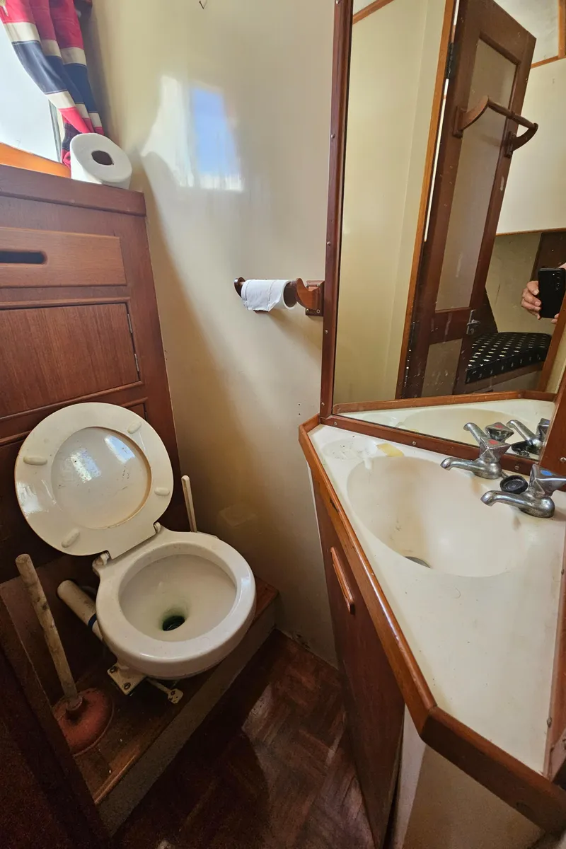 Slide: The Image of 1973 Grand Banks 36 Classic boat bathroom with toilet, sink, and mirror. - 13