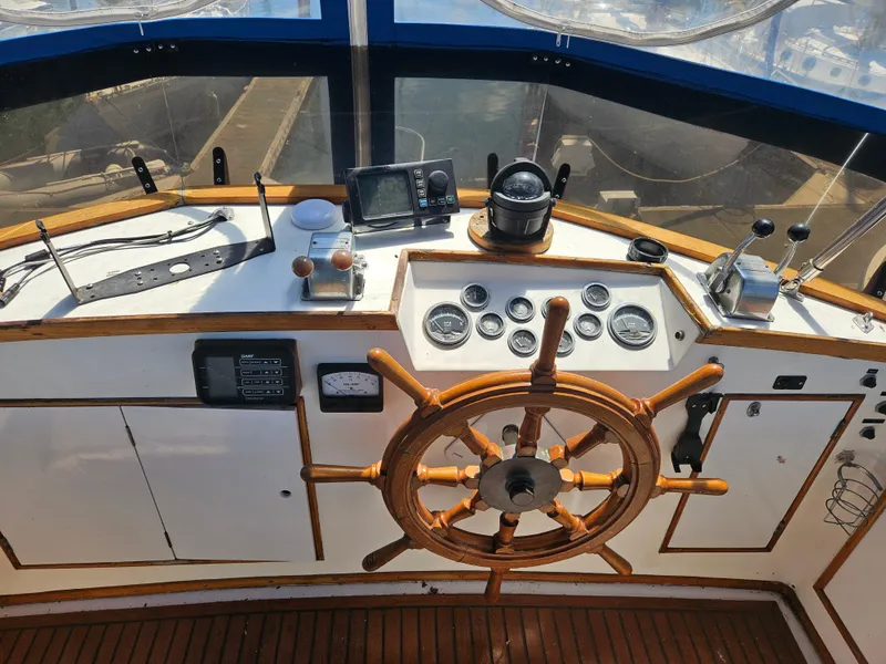 Slide: The Image of Helm of 1973 Grand Banks 36 Classic boat with wooden wheel and navigation instruments. - 14