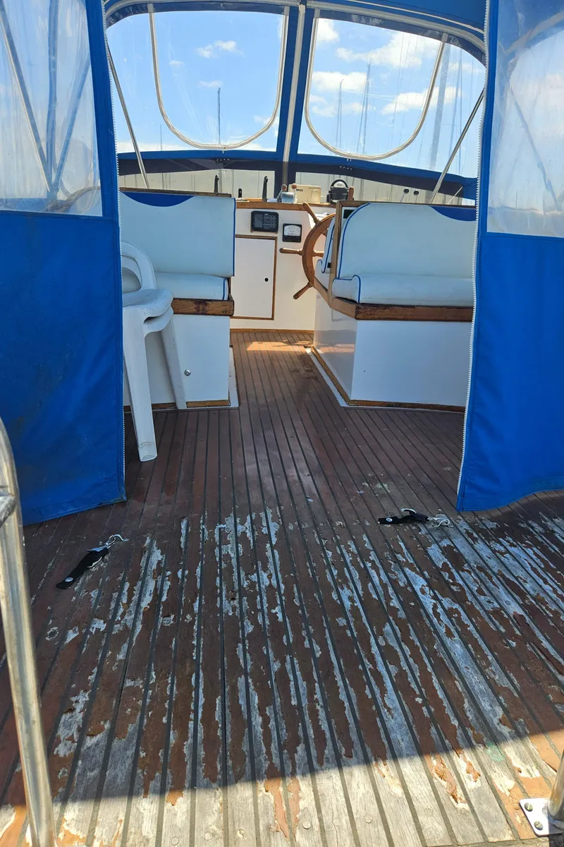 Slide: The Image of 1973 Grand Banks 36 Classic boat interior with wooden flooring and blue canopy. - 16