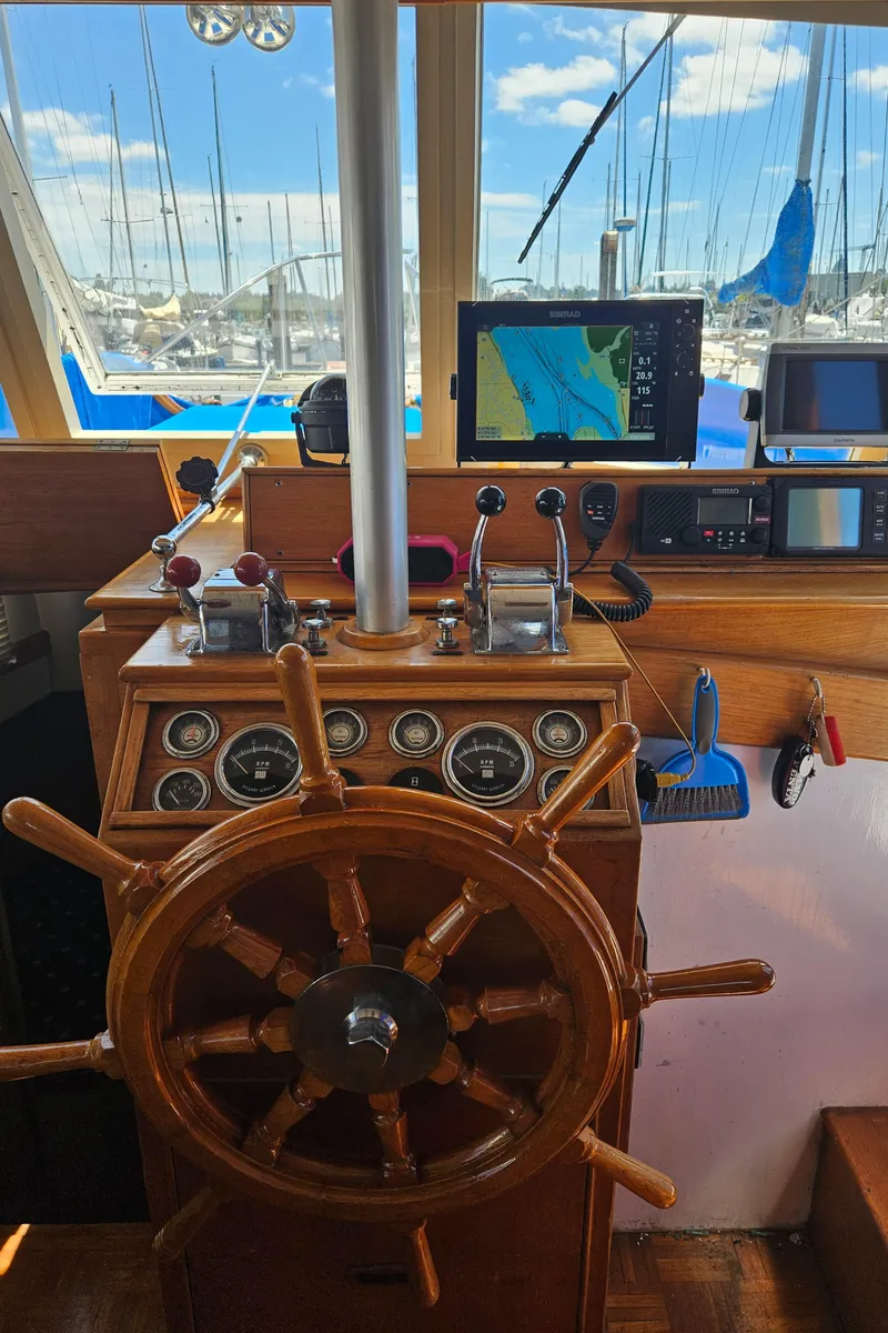 Slide: The Image of 1973 Grand Banks 36 Classic helm with wooden wheel, gauges, and navigation equipment. - 2