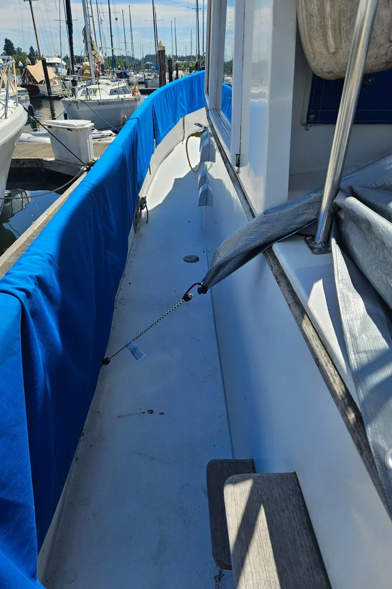 Slide: The Image of 1973 Grand Banks 36 Classic yacht deck with blue cover, docked in marina. - 28