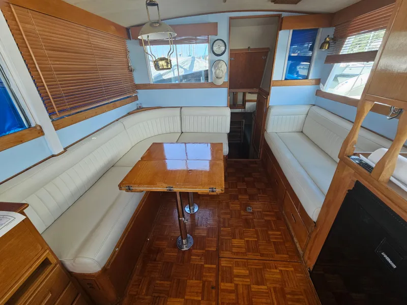 Slide: The Image of Interior of a 1973 Grand Banks 36 Classic yacht with wood accents and white seating. - 7