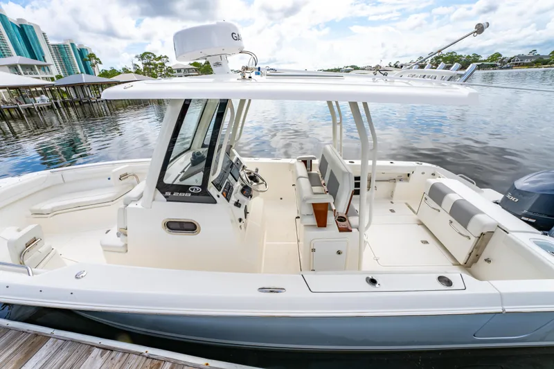 Slide: The Image of 2021 Pursuit S 288 Sport boat docked on calm water, showcasing spacious seating and helm. - 10
