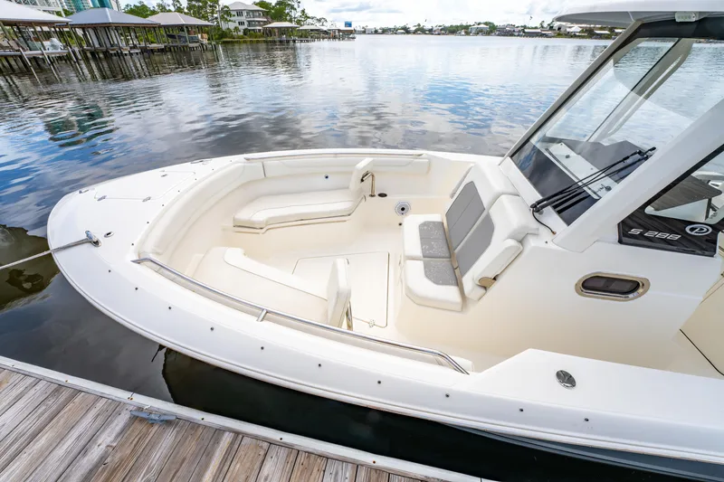Slide: The Image of 2021 Pursuit S 288 Sport boat docked, featuring spacious seating and sleek design. - 11