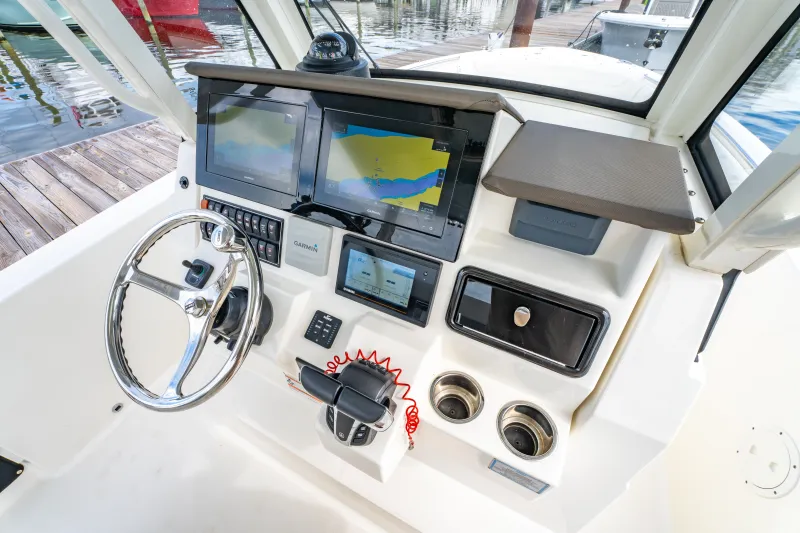 Slide: The Image of 2021 Pursuit S 288 Sport boat dashboard with steering wheel and navigation screens. - 17