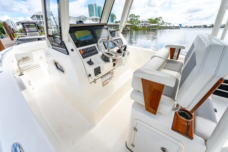 Slide: The Image of 2021 Pursuit S 288 Sport boat interior with helm, steering wheel, and seating. - 20