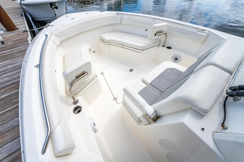 Slide: The Image of 2021 Pursuit S 288 Sport boat interior with white seating and deck, docked by water. - 21